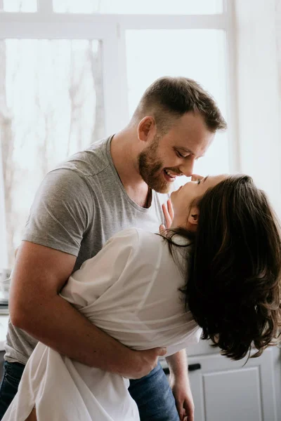 Romantisches junges Paar beim gemeinsamen Kochen in der Küche. das Mädchen im weißen Hemd. gemeinsames Frühstück. — Stockfoto