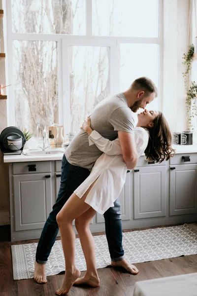 Romantiskt ungt par matlagning tillsammans i köket. Flickan i den vita skjortan. Frukost tillsammans. — Stockfoto
