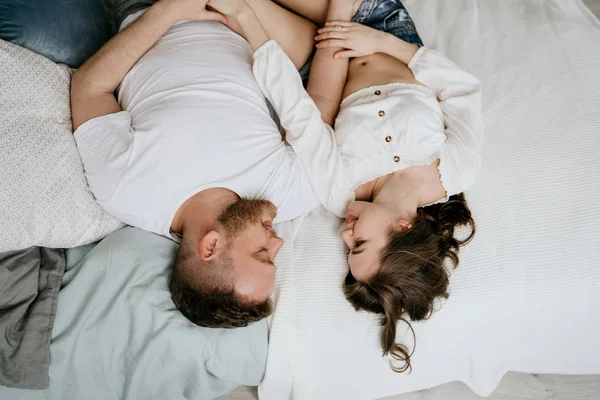 Un cuplu îndrăgostit în dormitor. Bruneta mai leneşă. Interior elegant . — Fotografie, imagine de stoc