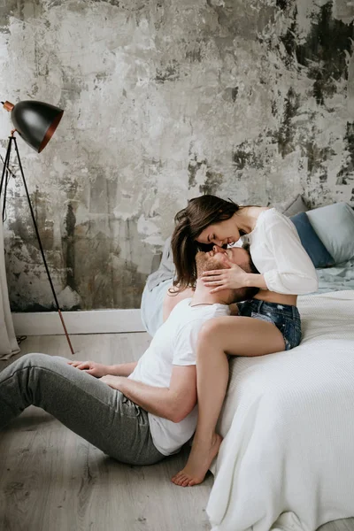 Couple in love in the bedroom. Slender brunette. Stylish interior. — Stock Photo, Image