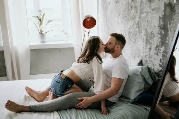 Couple in love in the bedroom. Slender brunette. Stylish interior. — Stock Photo, Image