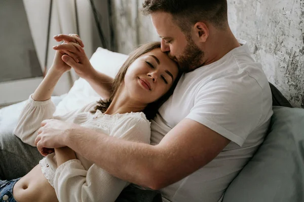 Verliebtes Paar im Schlafzimmer. schlanke Brünette. stilvolles Interieur. — Stockfoto