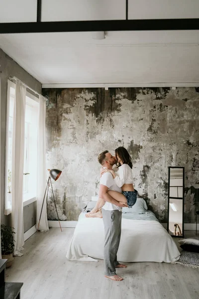 Par i kärlek i sovrummet. Smal brunett. Snygg inredning. — Stockfoto