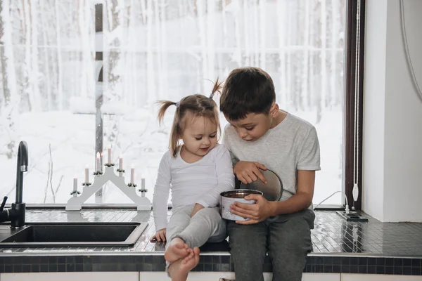 La famille est assise à la fenêtre et regarde la forêt d'hiver. Bon esprit du Nouvel An. Matin en pyjama . — Photo