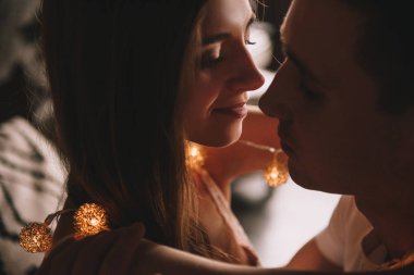 Yatak odasındaki yatakta bir çift. İçi karanlık. Yeni yıl ve Noel. Öpücükler ve sarılmalar. Sevgi. Beyaz kazak ve yüksek çoraplar. Romantik bir buluşma. Randevu aşıkları..