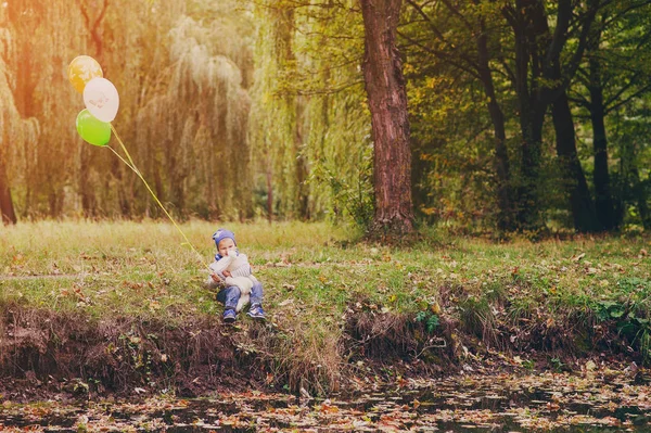 Chlapec sedí v parku — Stock fotografie