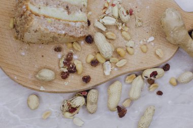 Tahtada bir dilim kek, yanında da zencefilli fındık var.