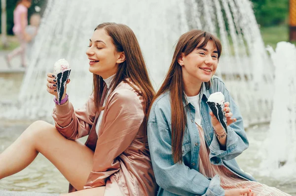 Çeşme ve gidiş dondurma yakın oturan iki kız. — Stok fotoğraf