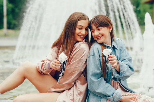 Δύο κορίτσια που κάθονταν κοντά στην κρήνη και πηγαίνοντας με παγωτό. — Φωτογραφία Αρχείου