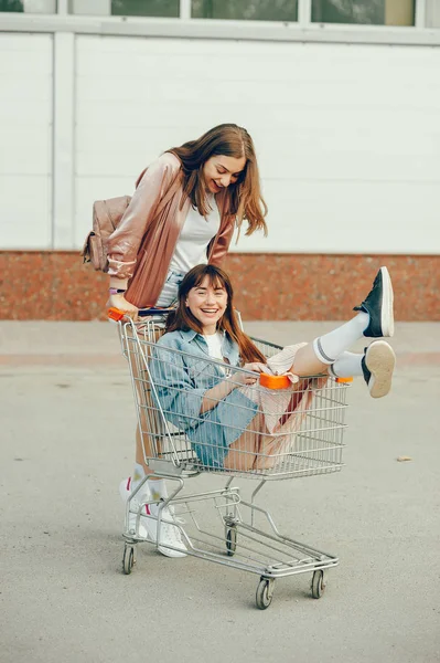 WO dívky jsou procházky po městě a jezdit ve vozíku. — Stock fotografie