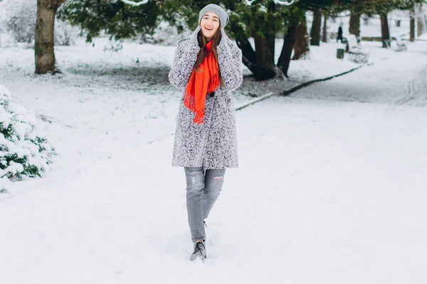 帽子やスカーフで若くてアクティブな女の子は冬の雪に覆われた公園を散策します — ストック写真