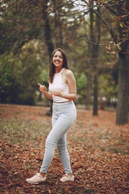 Güz parkında yürüyen güzel genç kız