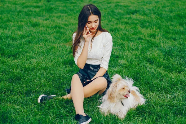 Het meisje wandelingen in het park met haar hond — Stockfoto