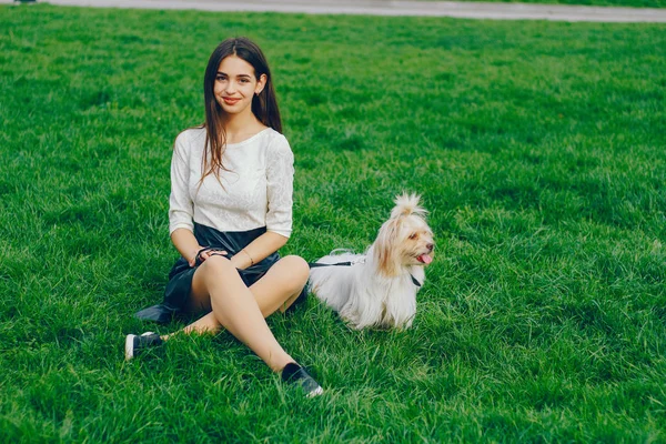 Gadis itu berjalan di taman dengan anjingnya — Stok Foto