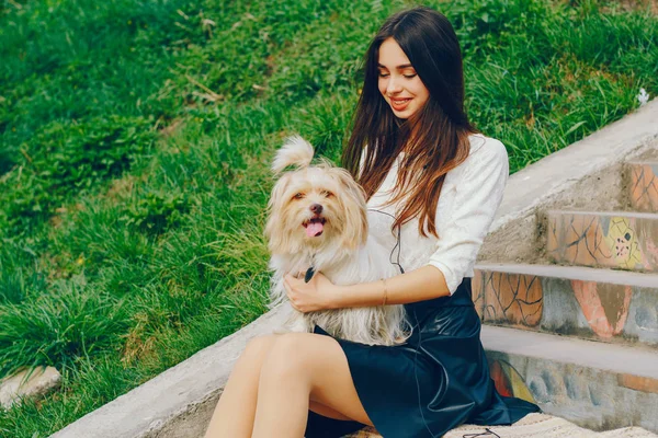 Het meisje wandelingen in het park met haar hond — Stockfoto