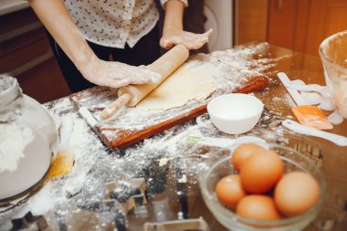 beyaz bir gömlek genç bir kadın evde mutfakta yemek hazırlanıyor 