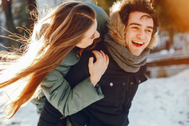 Sevgili çift kış parkında yürüyor.