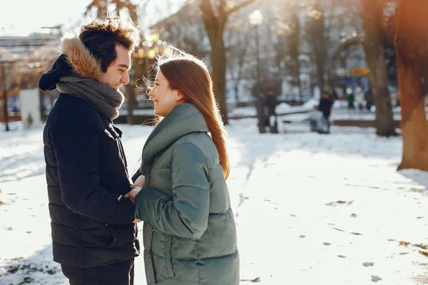 Sevgili çift kış parkında yürüyor.