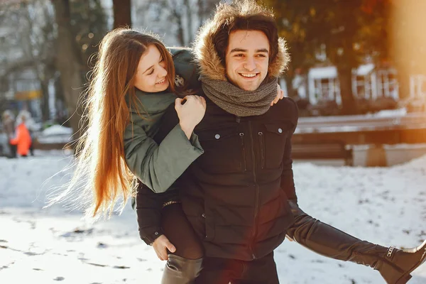 Sevgili çift kış parkında yürüyor.