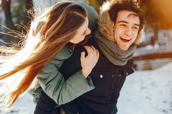 Sevgili çift kış parkında yürüyor.