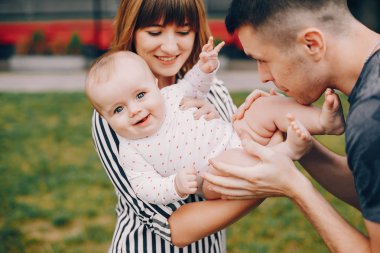 Yaz parkında oynayan sevimli bir aile.