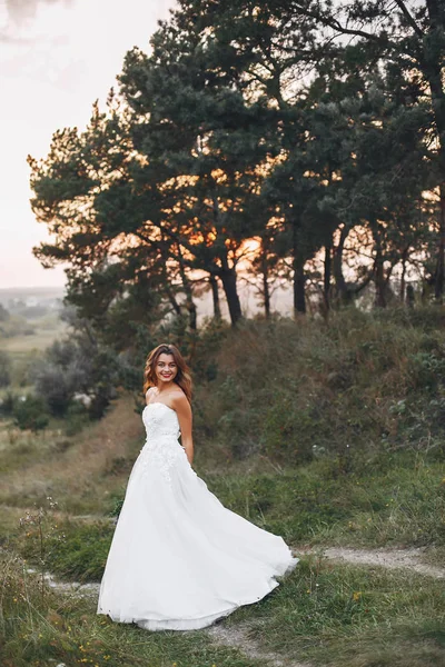 Bella sposa che cammina in un campo estivo — Foto Stock
