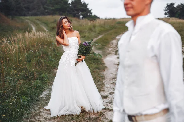 Bella coppia nuziale in un campo estivo — Foto Stock