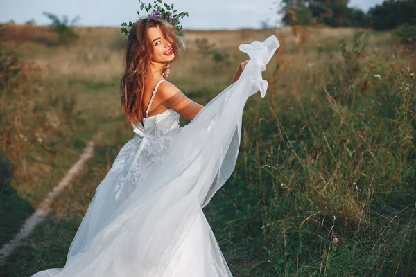 Прекрасная невеста гуляет по летнему полю — стоковое фото