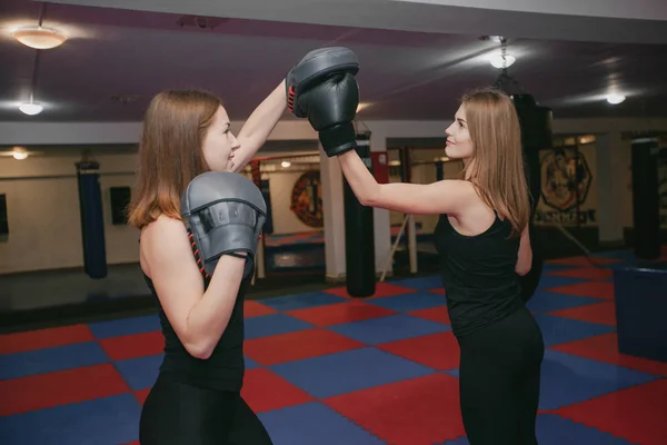 Duas meninas estão envolvidas em boxe no ginásio — Fotografia de Stock