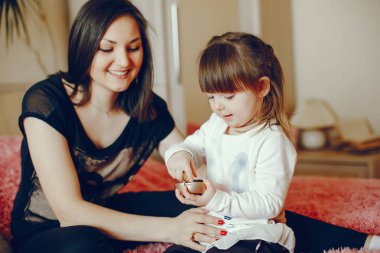 Anne ile kızı yatağa oturmuş