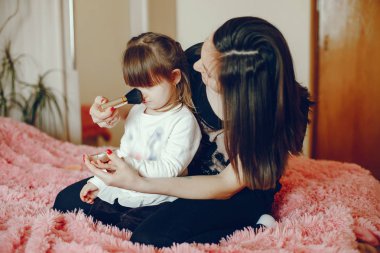 Anne ile kızı yatağa oturmuş