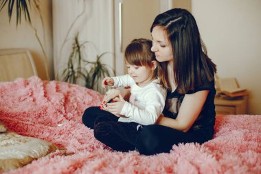 Anne ile kızı yatağa oturmuş