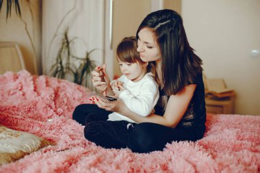 Anne ile kızı yatağa oturmuş