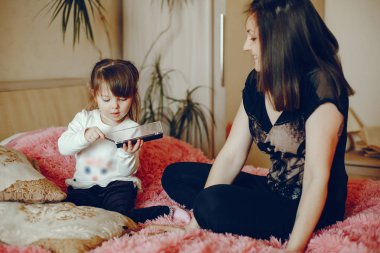 Anne ile kızı yatağa oturmuş