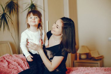 Anne ile kızı yatağa oturmuş