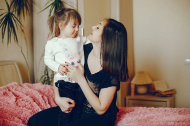 Anne ile kızı yatağa oturmuş