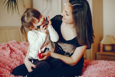 Anne ile kızı yatağa oturmuş