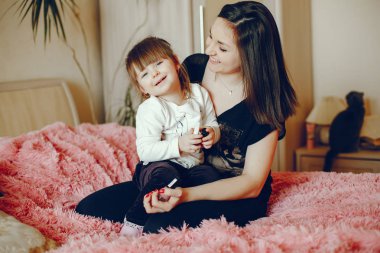 Anne ile kızı yatağa oturmuş