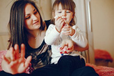 Anne ile kızı yatağa oturmuş