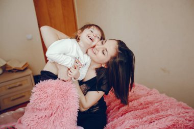 Anne ile kızı yatağa oturmuş