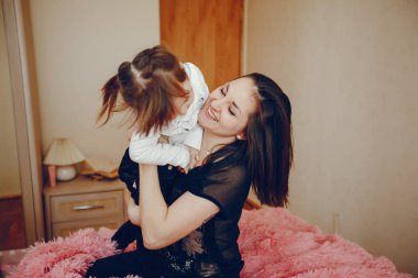 Anne ile kızı yatağa oturmuş