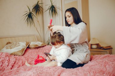 Anne ile kızı yatağa oturmuş