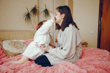 Anne ile kızı yatağa oturmuş