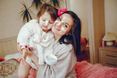 Anne ile kızı yatağa oturmuş