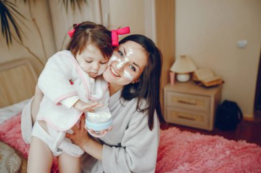 Anne ile kızı yatağa oturmuş