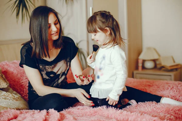 Mãe com filha sentada em uma cama — Fotografia de Stock