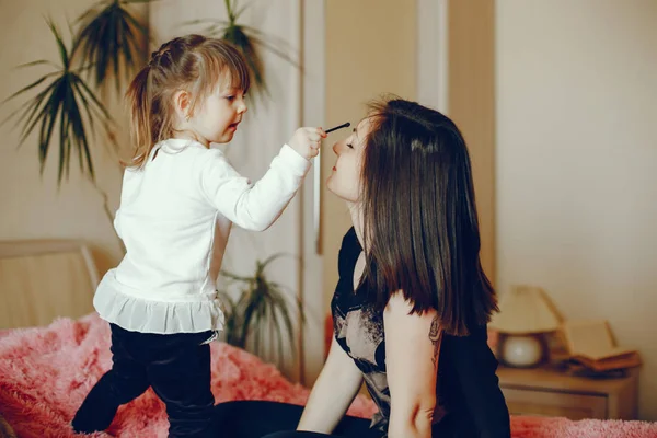 Mother with daughter sitting on a bed — Stock Photo, Image