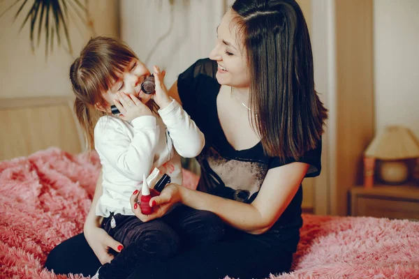 Mãe com filha sentada em uma cama — Fotografia de Stock