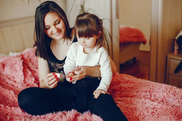 Mother with daughter sitting on a bed — Stock Photo, Image