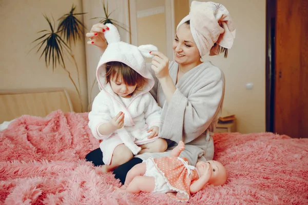 Mãe com filha sentada em uma cama — Fotografia de Stock